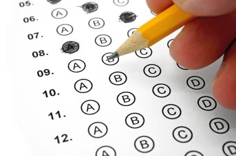 Pencil filling in bubbles on a multiple-choice assessment sheet
