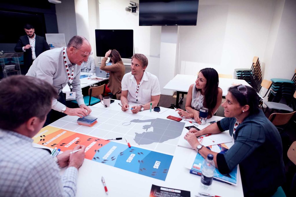 Senior Innovation Advisor Chris Docherty of Planbox hands out cards during a breakout session.