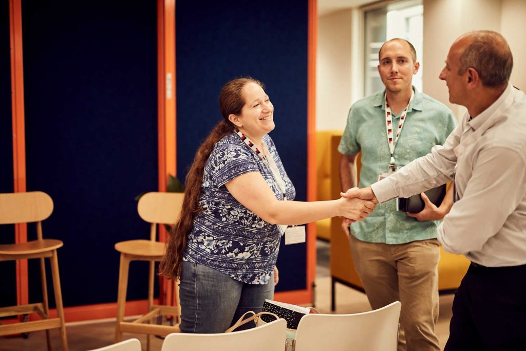 Marie Mahoney of the US Air Force and Andy Katz of PA Consulting shake hands.