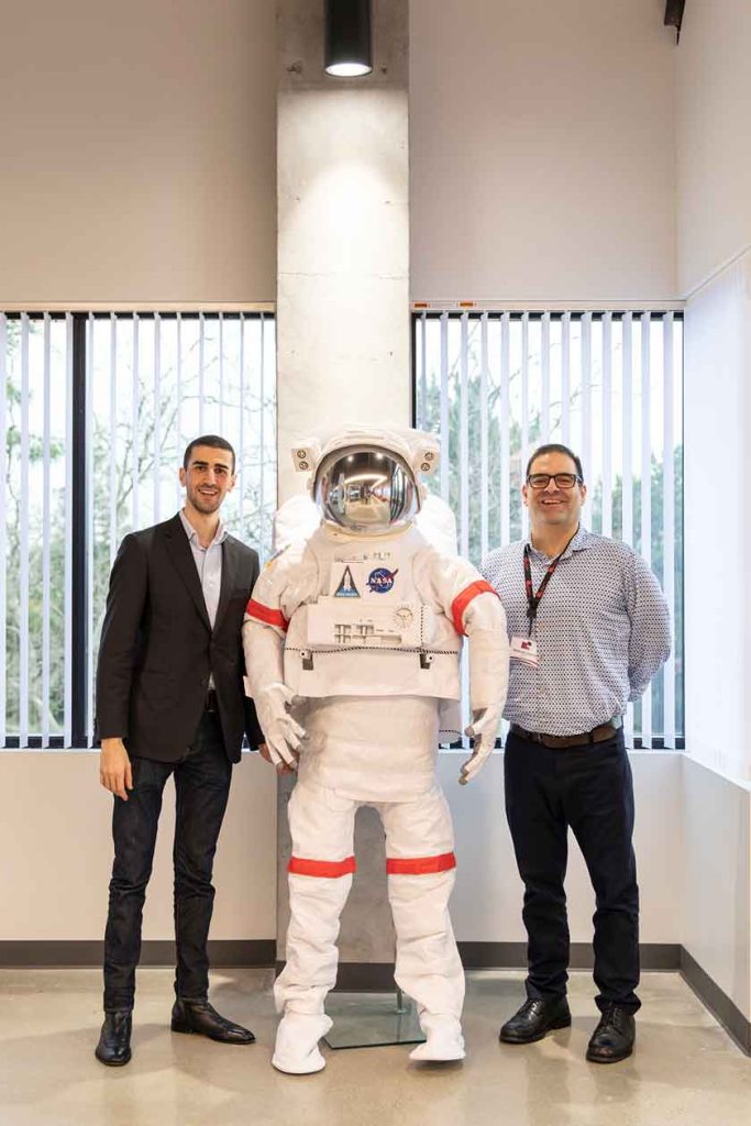 Arthur Liberian and Sean Nazarian of Planbox pose with a spacesuit. W.L. Gore fibers and cables have long been used by NASA on various space missions.