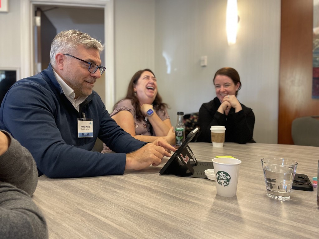 Impact participants laugh together in a breakout session.