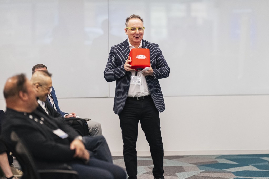 Scott Kirsner of InnoLead kicks off the conference, holding the official Takeda throwable microphone.