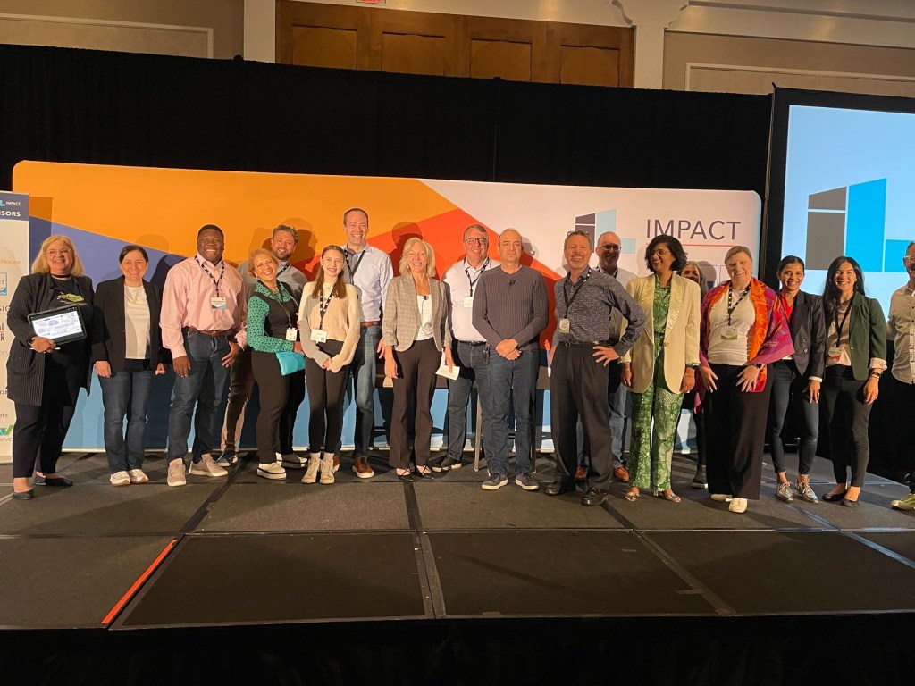 Impact speakers and InnoLead team members pose for a group picture on the mainstage.