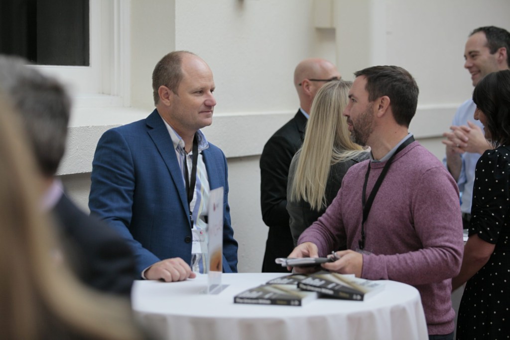 Mark Simoncelli, Chief Revenue Officer of Mach49, makes a connection with Tim Turkowski, Strategy Development Director at Enterprise Holdings, during a networking break.